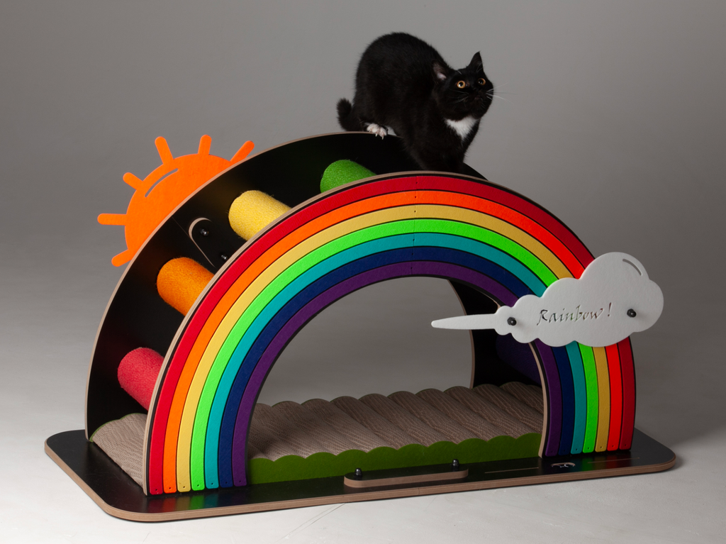 A black cat perched on top of the large Rainbow Bridge cat scratcher, highlighting its durability for heavy cats.