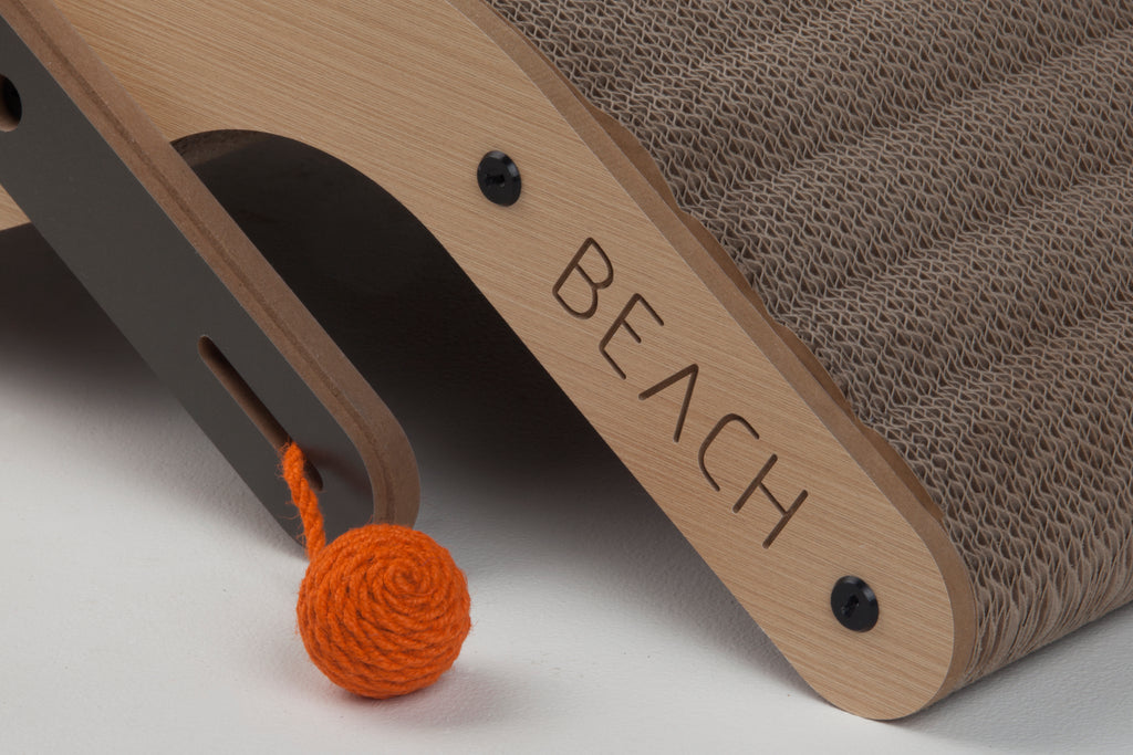 Detail shot of the "BEACH" branding and the interactive orange toy ball on the side of the cat scratcher.