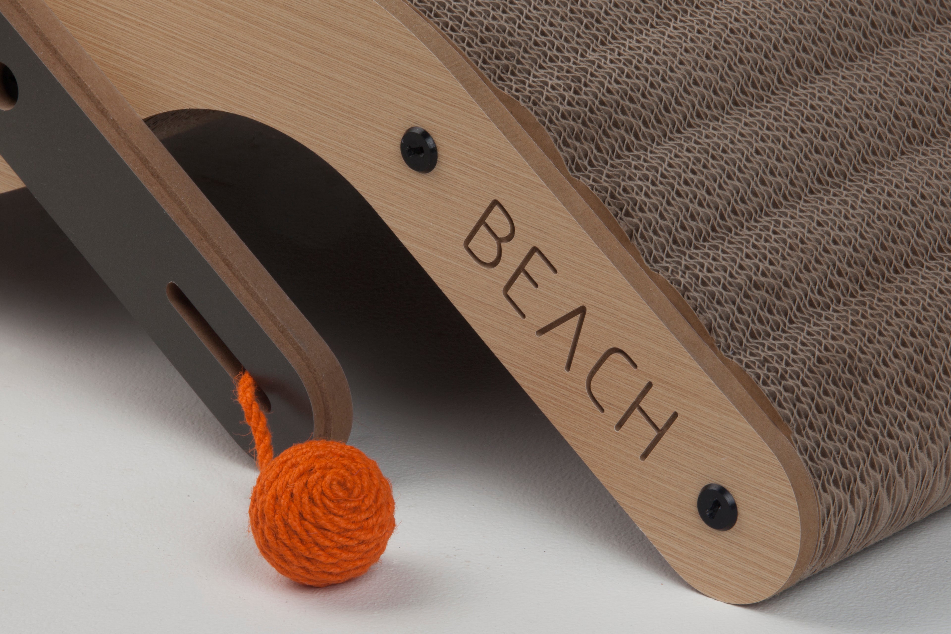 Detail shot of the "BEACH" branding and the interactive orange toy ball on the side of the cat scratcher.