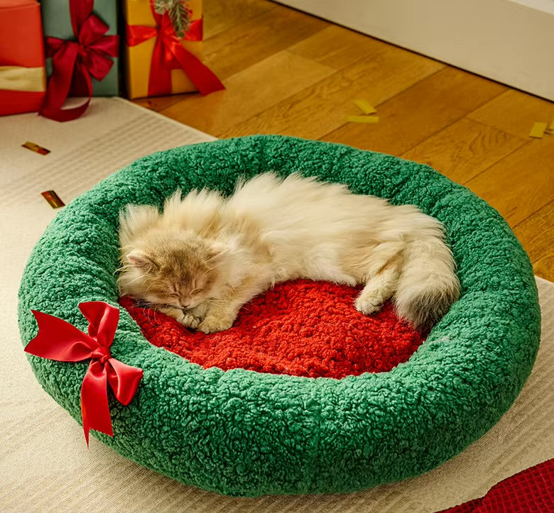 Fluffy cat curled up asleep on the soft red centre cushion of the Nekono Calming Donut Cat Bed
