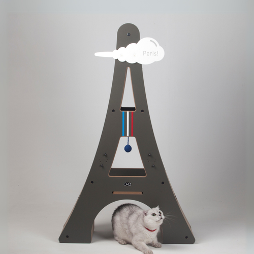 White cat playing inside the base of the Paris-inspired Eiffel Tower cat tree, showing its sturdy MDF structure.