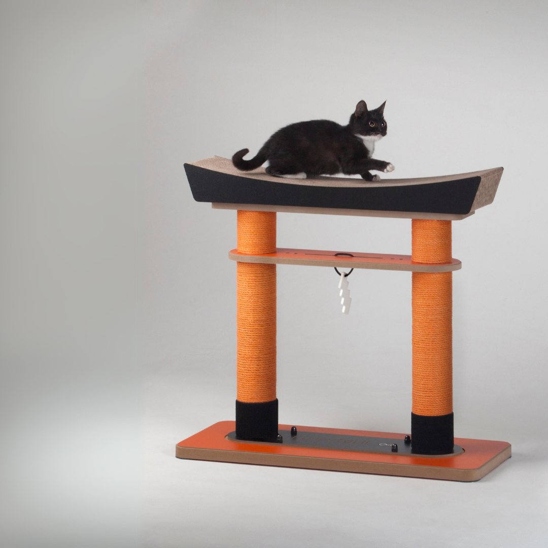 Black cat resting comfortably on the curved corrugated platform of the Torii gate cat scratcher.