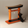 Black cat scratching the orange jute rope posts of the Nekono Japan Torii Cat Tree