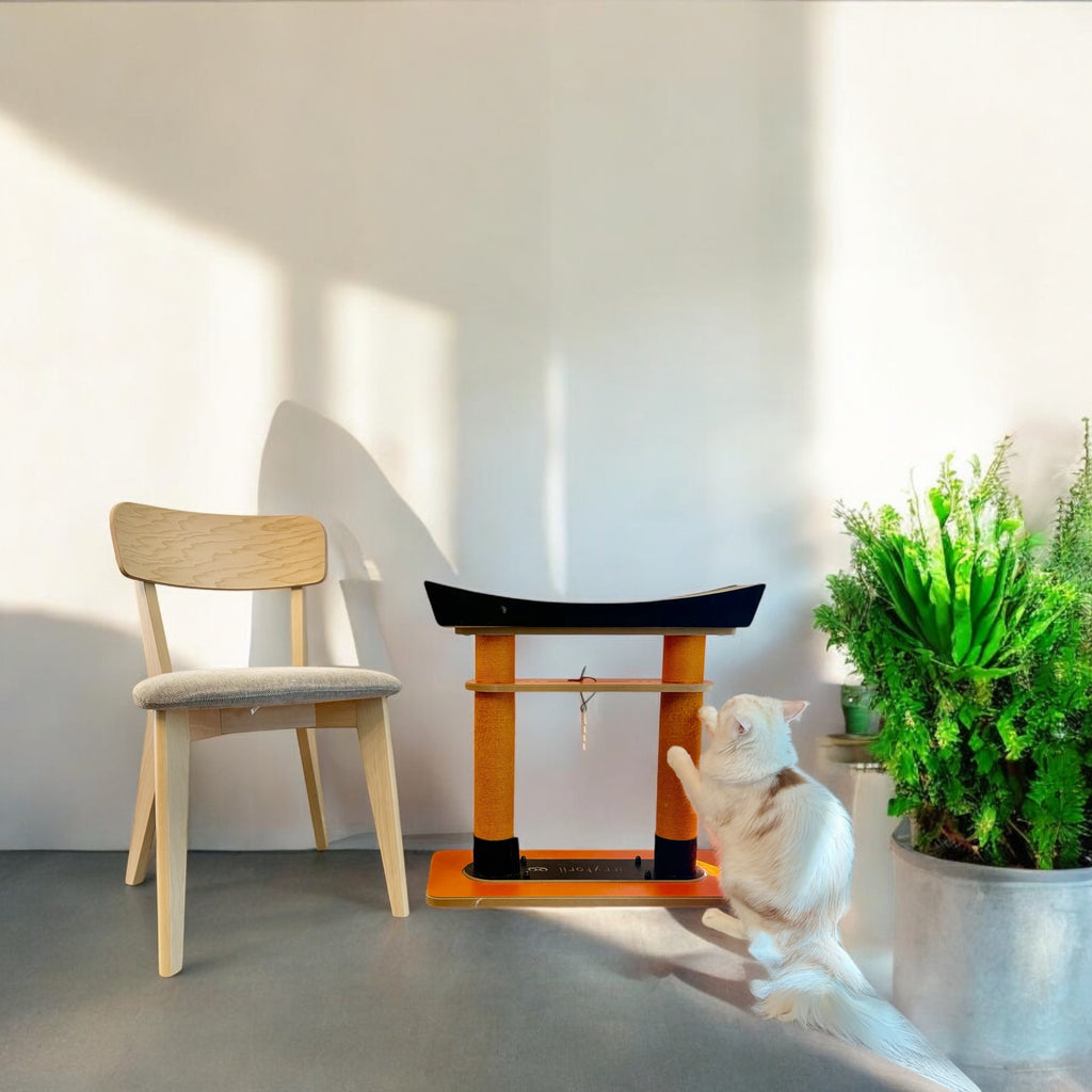 The Nekono Torii Cat Scratcher sitting in a sunlit living room next to a wooden chair, showcasing its elegant home decor fit.