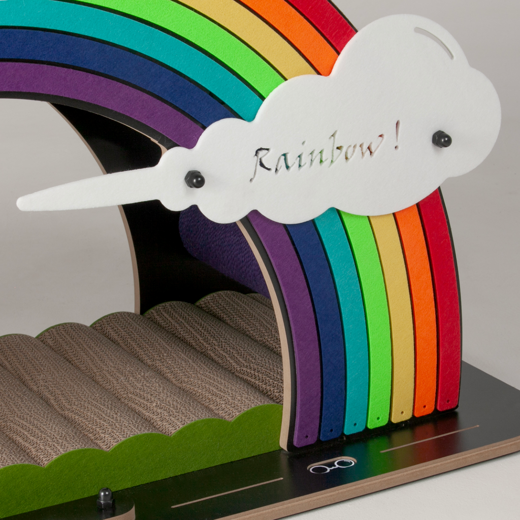 Close-up of the "Rainbow!" engraved cloud and the textured corrugated scratching surface of the bridge.