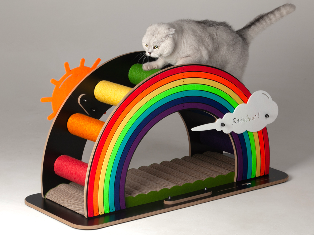 A white cat perched on top of the large Rainbow Bridge cat scratcher, highlighting its durability for heavy cats